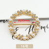 A gold-toned metal ring clip featuring small diamonds and pearl accents, shown with a measurement line.