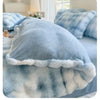 A light blue and white fluffy fleece duvet cover with a white trim is displayed on a bed.