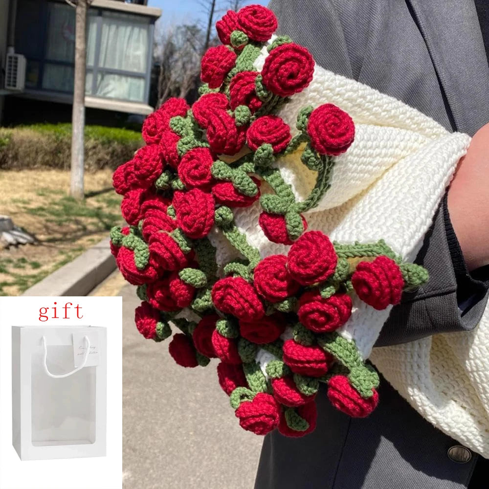 A handmade rose crochet blanket bouquet is displayed next to a white gift bag.