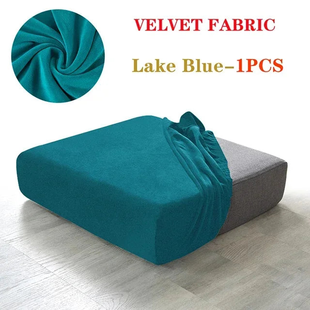 A teal velvet fabric is shown folded and draped over a gray sofa seat cover.