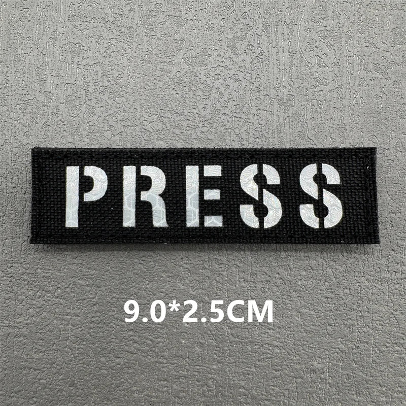 Black rectangular press patch with white text PRESS and dimensions 9.0x2.5cm