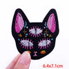 Black felt cat face embroidered with pink and white feathers and colorful thread details