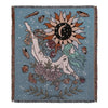 A teal throw blanket featuring a bohemian geometric design with a large sun and floral elements.