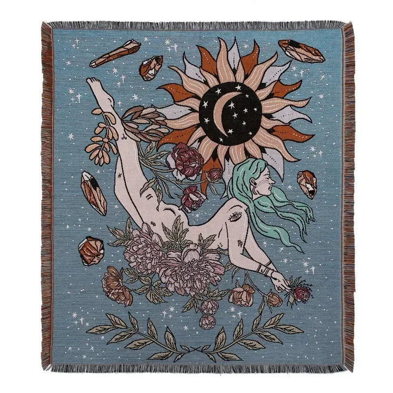 A teal throw blanket featuring a bohemian geometric design with a large sun and floral elements.