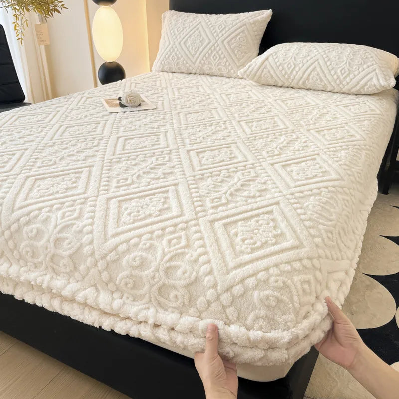 A white plush jacquard mattress cover is shown on a black bed, featuring a diamond quilted pattern.