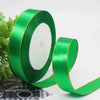 Roll of bright green satin ribbon with a gold edge for gift wrapping and crafts