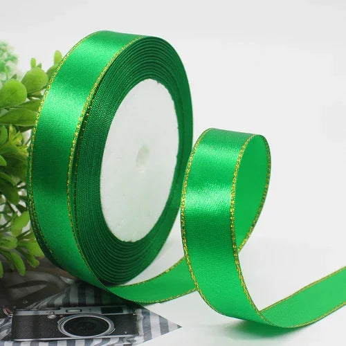Roll of bright green satin ribbon with a gold edge for gift wrapping and crafts