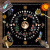 A dark mat featuring a circular design of the moon, stars, and floral elements for tarot readings.
