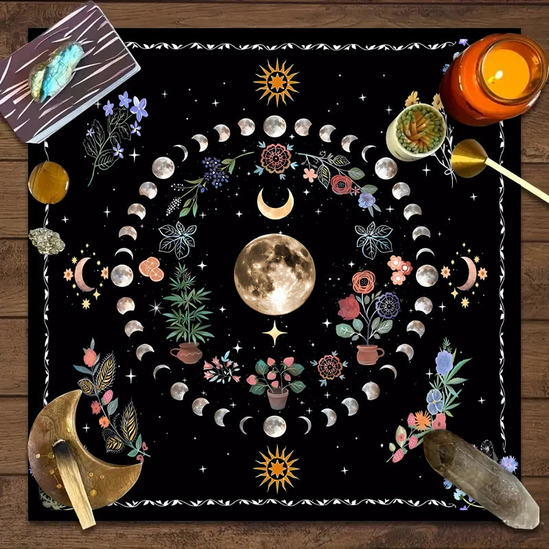 A dark mat featuring a circular design of the moon, stars, and floral elements for tarot readings.