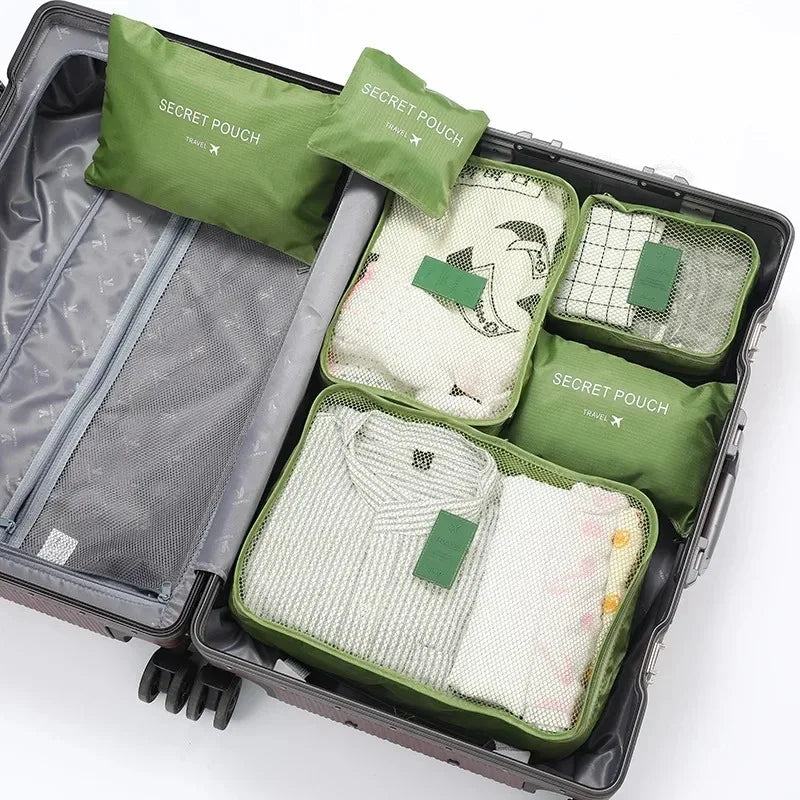 A set of six olive green and beige travel packing cubes inside a gray storage case.