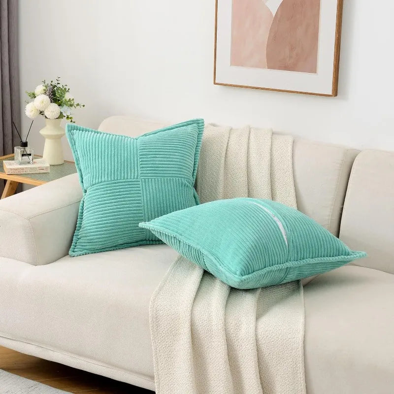 A teal striped corduroy lumbar support pillow cushion resting on a light-colored sofa.