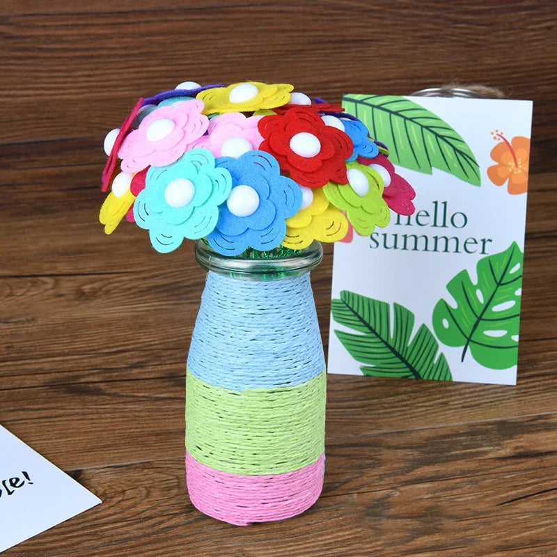 A bouquet of colorful felt flowers in various shades of pink, blue, yellow, and red displayed in a glass vase.