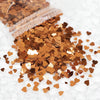 A pile of sparkling copper and gold heart-shaped glitter filler for epoxy art.