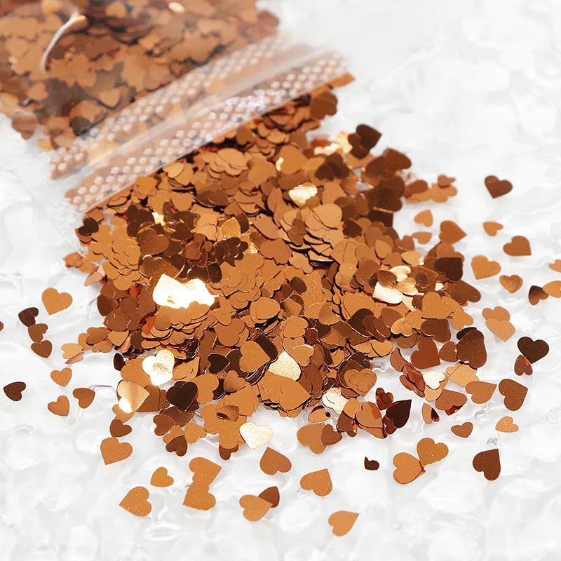 A pile of sparkling copper and gold heart-shaped glitter filler for epoxy art.