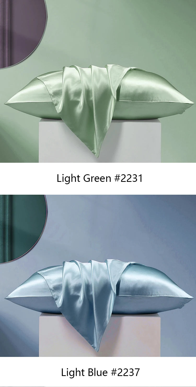 A light green silk pillowcase folded artistically on a white pedestal, next to a light blue version.