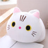 A white and pink soft cat plush pillow cushion with black accents is shown on a light surface.