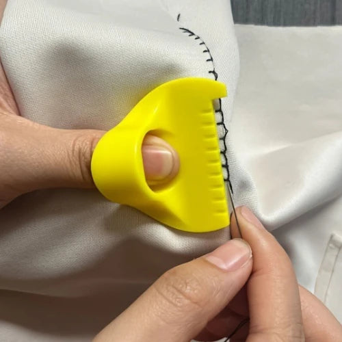 A hand is using a yellow sewing guide tool with 3mm spacing on white fabric.