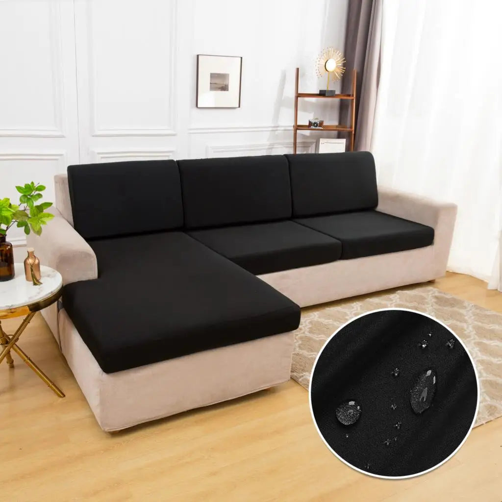 A beige sofa cushion protector cover is shown on a light-colored sofa, with a black circular mat nearby.