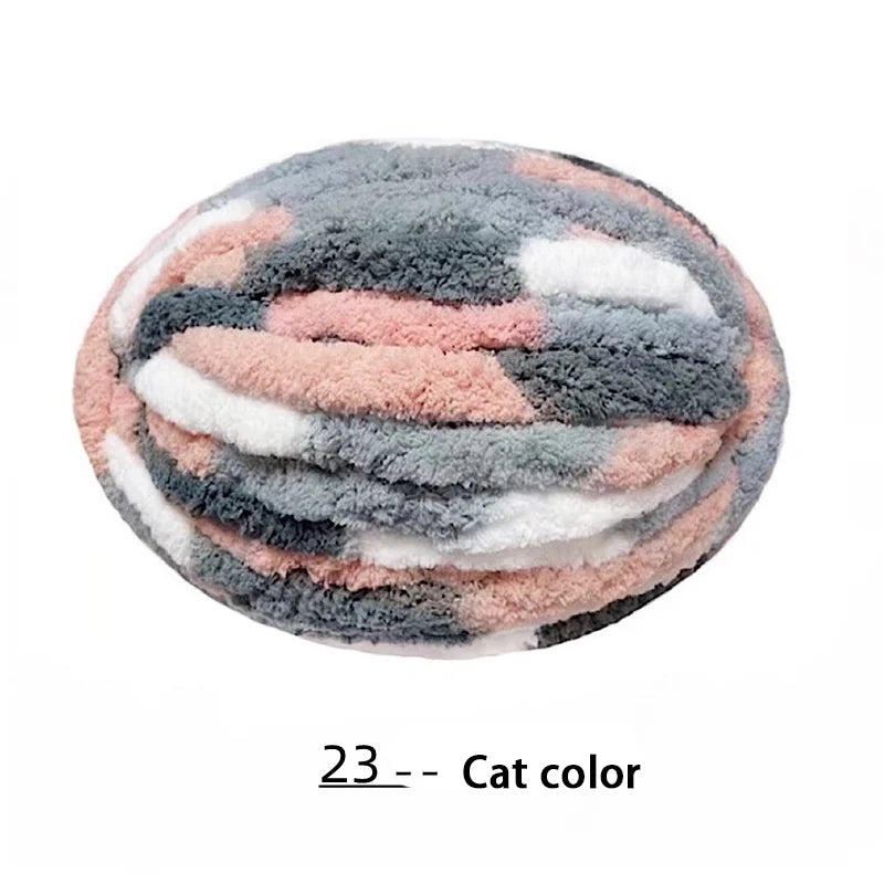 A round, fluffy yarn ball featuring a mottled pattern of gray, pink, and white colors.