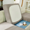 A light gray jacquard sofa slipcover with a white back cushion and blue accent cushion.