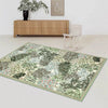 A rectangular botanical area rug featuring green and white foliage patterns in a living room setting.