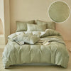 A light sage green embossed leaf duvet cover set displayed on a bed.