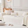 A white anti-scratch sofa cover draped over a light-colored sofa with decorative pillows.