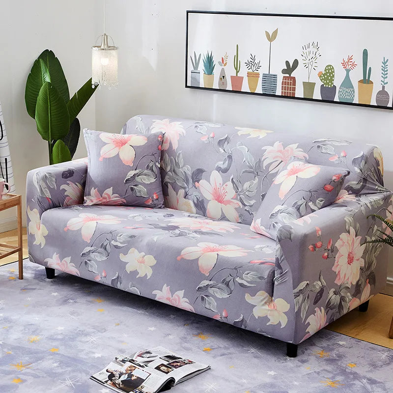 A gray floral patterned universal stretch sofa and chair slipcover displayed in a living room setting.