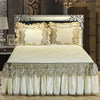 A set of three bed skirts and pillowcases featuring cream and silver lace detailing on a quilted bedspread.