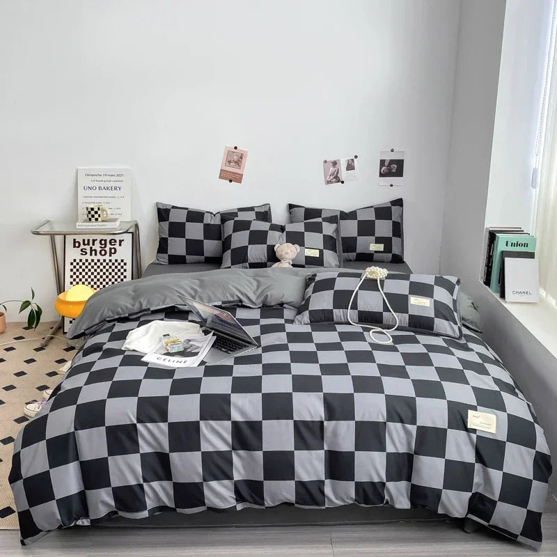 A black and white plaid duvet cover set displayed on a bed with pillows and accessories.