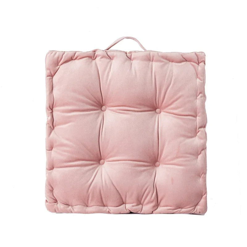A square, blush pink quilted cotton throw pillow with a loop for sofa or floor seating.