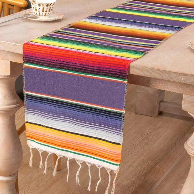 Colorful cotton Mexican sarape table runner with horizontal stripes in purple, orange, green, and yellow.
