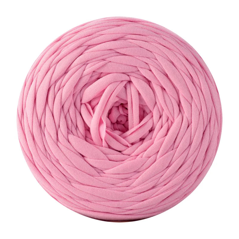 Pink soft t-shirt yarn coiled into a round ball for crochet