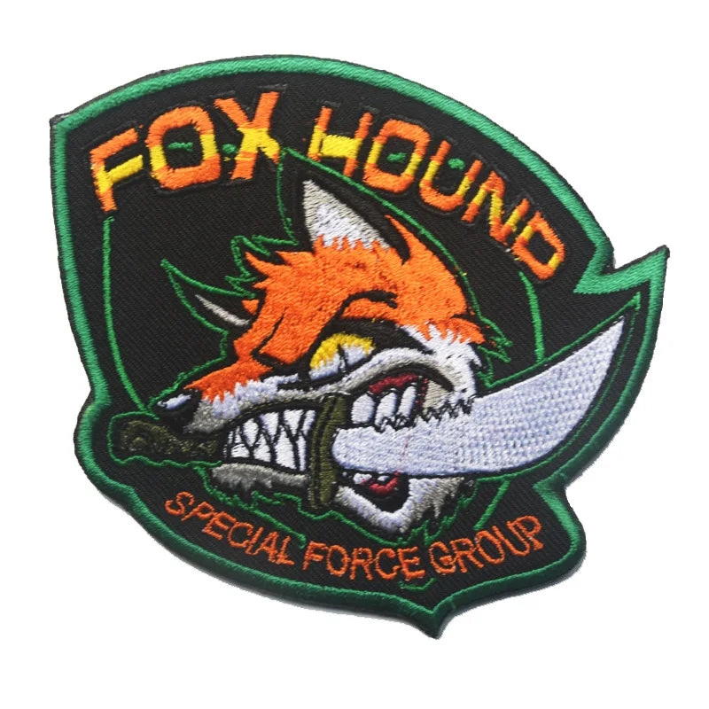 An embroidered patch featuring an orange fox head with a knife, surrounded by the text FOX HOUND and SPECIAL FORCE GROUP.