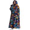 A woman wearing a colorful, pumpkin-themed sherpa fleece oversized blanket hoodie.