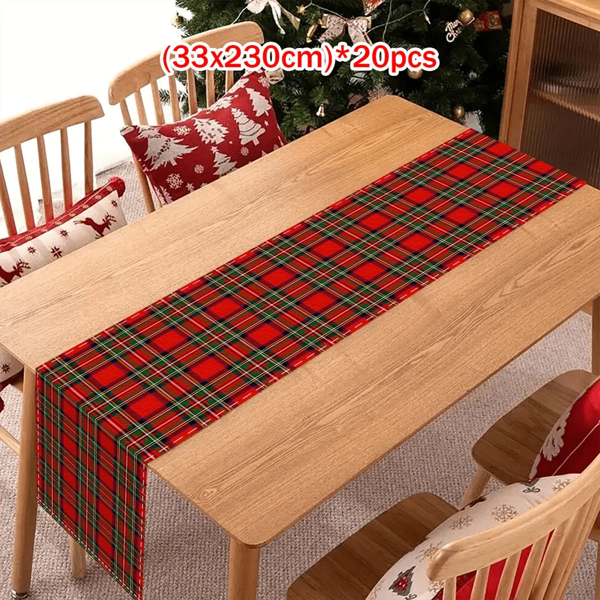 A wooden table is decorated with a red and green tartan Christmas table runner and plaid cushions.