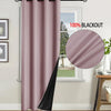 A floor-length mauve blackout curtain hanging on a rod next to a window.