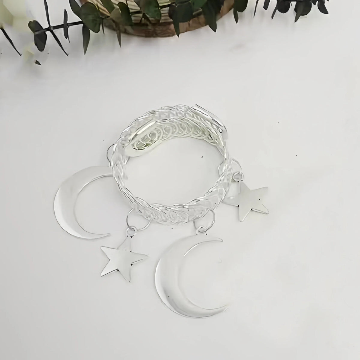 A set of two silver-toned vintage curtain clips featuring a woven star and crescent moon design.