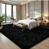 A plush black long-pile area rug in a modern bedroom setting with a white bed and wooden accents.