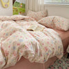 A pink floral microfiber duvet set with light pink and green patterns is displayed on a bed.