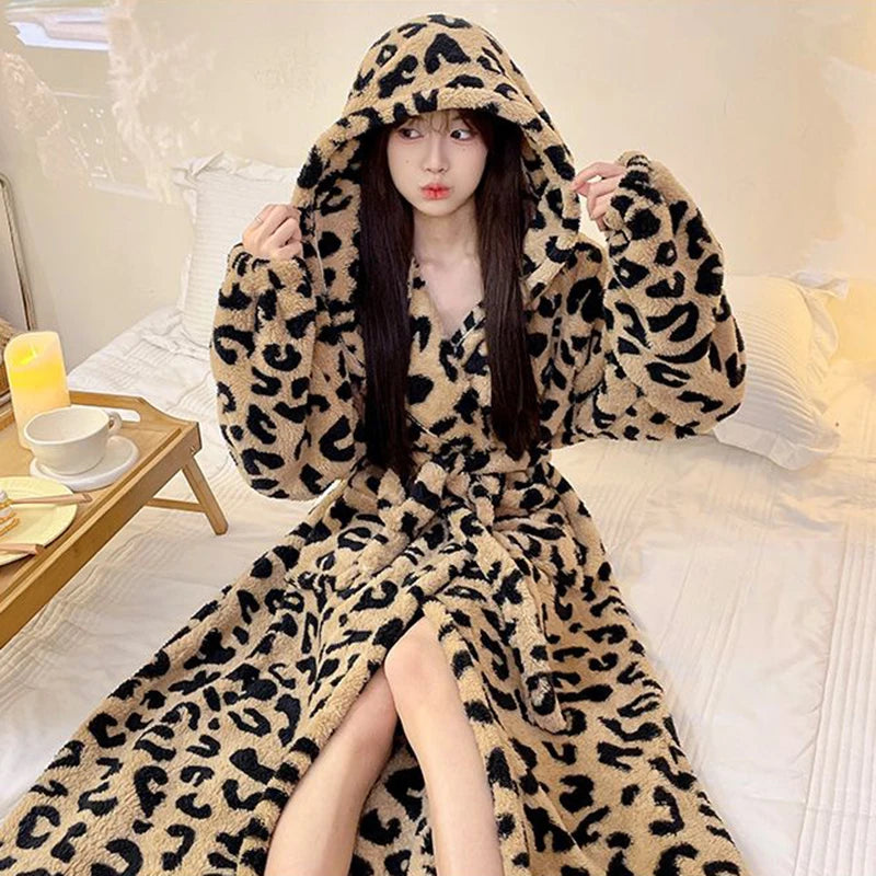 A woman wearing a long leopard print flannel kimono robe indoors.