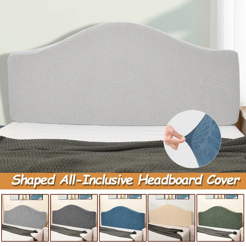 A shaped, inclusive headboard cover in light gray fabric shown on a bed.