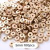 A pile of small gold-colored geometric acrylic beads for jewelry making