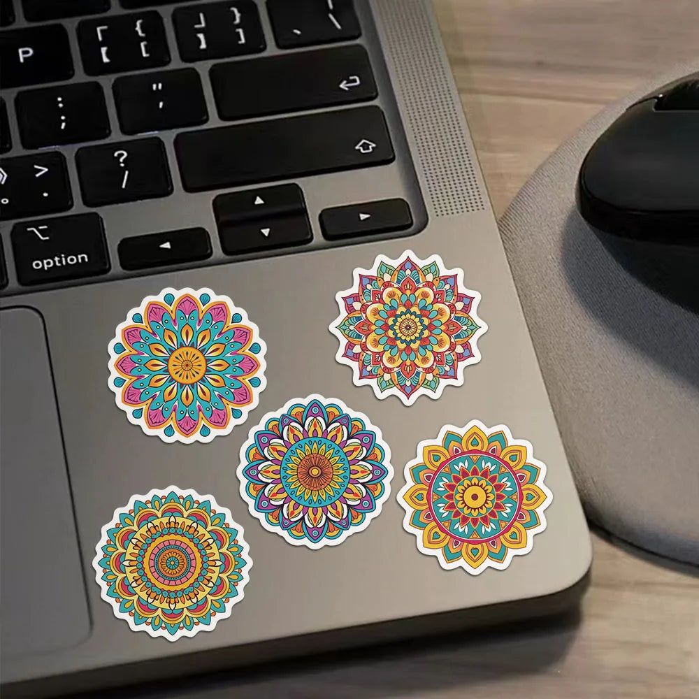 Colorful mandala graffiti stickers are displayed on a laptop keyboard and surface.
