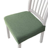 A light green quilted fabric seat cover for a white wooden bar or dining chair.