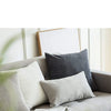 A gray sofa with white and charcoal striped velvet corduroy cushion covers and a framed picture.