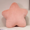 A soft, pink star-shaped decorative throw pillow with a fluffy texture.
