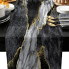 A black and gray abstract marble linen table runner with gold veining on a dark table.
