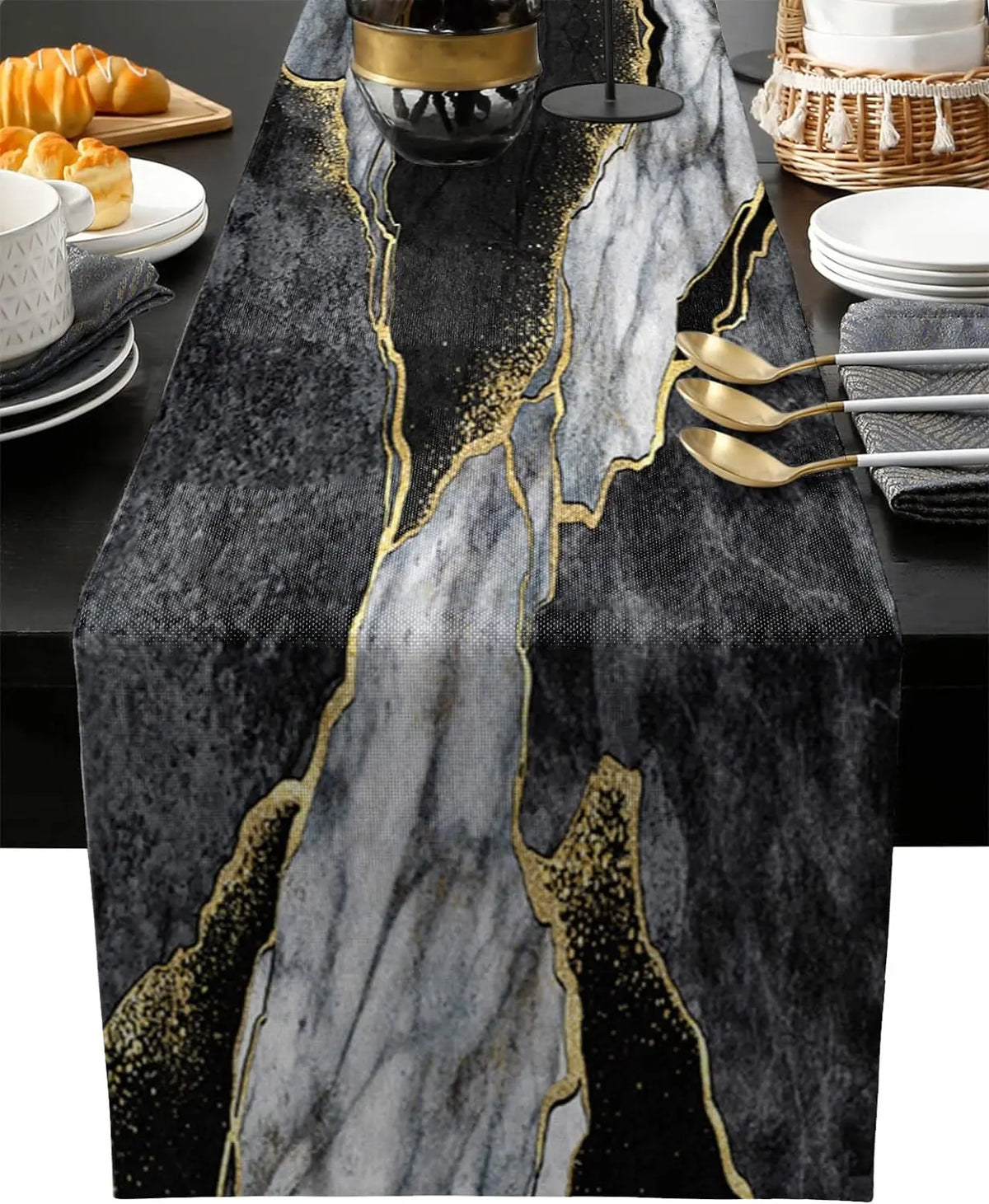 A black and gray abstract marble linen table runner with gold veining on a dark table.