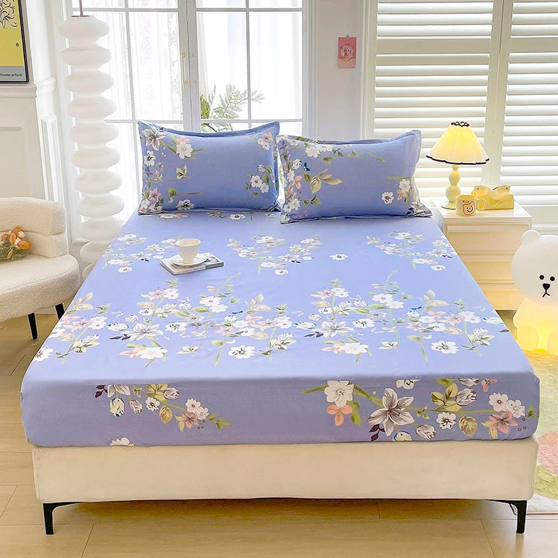 A light blue floral print fitted bed sheet with matching pillows displayed on a bed.
